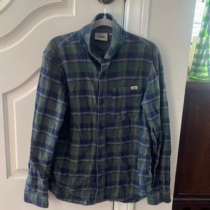 This nice green white and black Vans button up flannel is in good condition.